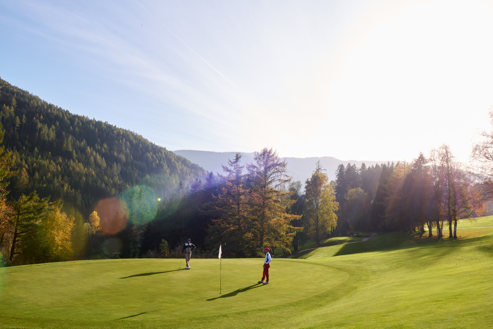 Golfclub Schloss Pichlarn als Partnergolfplatz des Gut Weissenhof mit Spielern am Green und Abendlicht