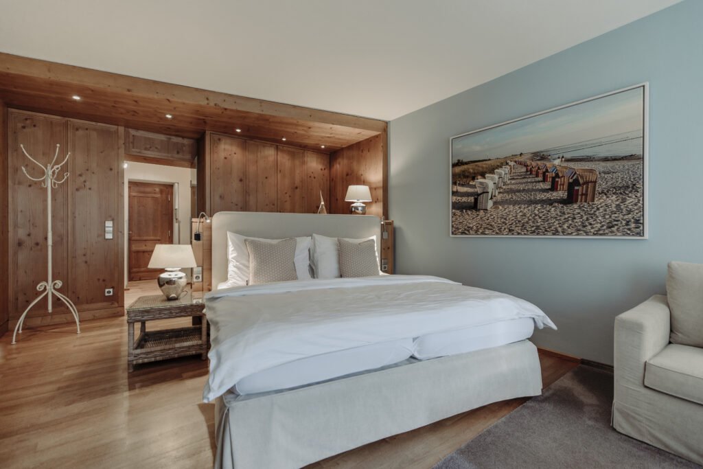 Schlafbereich der Komfortsuite mit viel Holz und warmen Farben